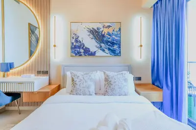 a bedroom with a bed with blue curtains and a mirror at TRPS - Act Towers, Downtown Dubai - Full Burj Khalifa View, High-End 3BR plus Maids in Dubai