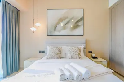 a bedroom with a white bed with towels on it at TRPS - Act Towers, Downtown Dubai - Full Burj Khalifa View, High-End 3BR plus Maids in Dubai