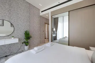 a bedroom with a large white bed and a mirror at Iconic Binghatti Royale! Private Pool in Your Balcony! 5 Star Amenities! in Dubai