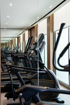 a row of treadmills in a gym at Binghatti Azure Minimal Luxe Studio with Pool & Gym in Dubai