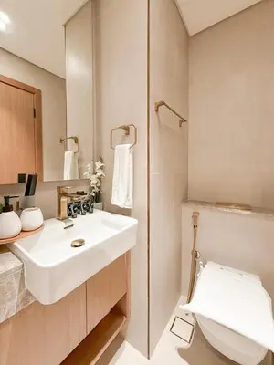 a bathroom with a white sink and a toilet at Binghatti Azure Minimal Luxe Studio with Pool & Gym in Dubai