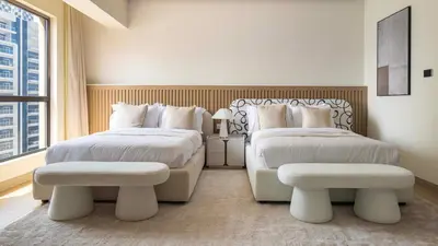 a white bedroom with two beds and a window at Maison Privee - Ultimate Luxury Penthouse with Pool & Marina Views in Dubai