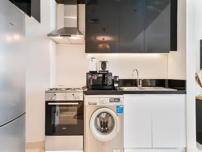a kitchen with a washing machine and a sink at Savis Homes - Luxury Studio in Business Bay with Amazing Pool - Capital Bay Tower A in Dubai