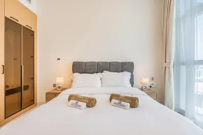 a bedroom with a large white bed with two pillows on it at Brand New Home with Amazing Facilities in Dubai