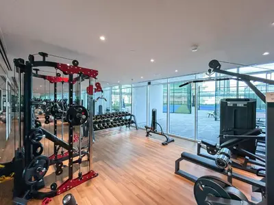 a gym with several treadmills and machines in a room at Brand New Home with Amazing Facilities in Dubai