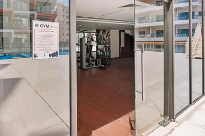 a hallway with glass doors in a building at Stylish 1BR Apartment Near Silicon Mall & Airport in Dubai