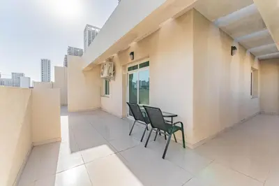 a balcony with chairs and a table on a building at HAVN - 1 bed in May Residence, JVC in Dubai