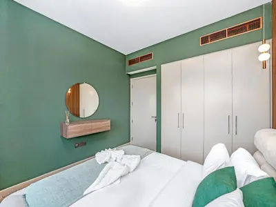 a bedroom with a white bed and a green wall at 4BR Villa in Resort-Style Gated Community with Lazy River in Arabian Ranches 3 in Dubai