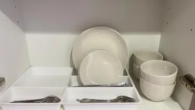 a white cabinet with two plates and silverware at Luxury Studio big Balcony in Dubai