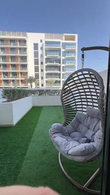 a wicker chair sitting on top of a balcony at Luxury Studio big Balcony in Dubai