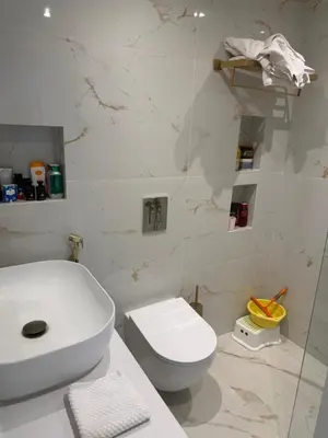 a white bathroom with a toilet and a sink at Marina 1 Bedroom appartment in Dubai