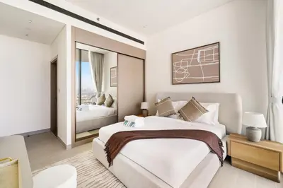 a white bedroom with a large bed and a window at New 1BR Urban Oasis with Pools & City Views in JVC in Dubai
