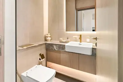 a bathroom with a white toilet and a sink at New 1BR Urban Oasis with Pools & City Views in JVC in Dubai