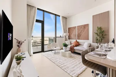 a living room with a couch and a table at New 1BR Urban Oasis with Pools & City Views in JVC in Dubai