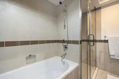 a bathroom with a bath tub and a shower at Stunning Burj & Fountain View Downtown 29 Blvd in Dubai