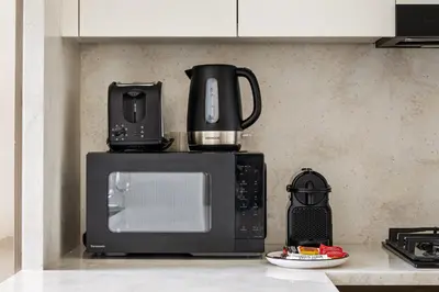 a microwave oven with a coffee maker on top of it at New Skyline 1BR with Private Pool in Binghatti Royale in Dubai