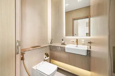 a bathroom with a sink and a toilet and a mirror at New Skyline 1BR with Private Pool in Binghatti Royale in Dubai