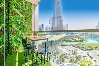 a balcony with a table and chairs overlooking a city at GRaNDE 2BR Best BURJ Khalifa & Fountain, Next to DXB Mall in Dubai
