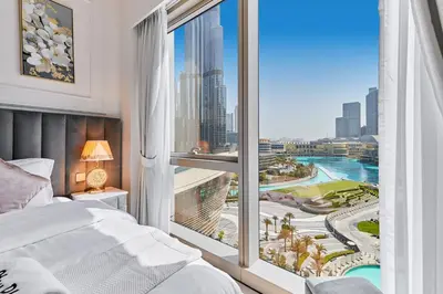 a bedroom with a large window with a view of the city at GRaNDE 2BR Best BURJ Khalifa & Fountain, Next to DXB Mall in Dubai