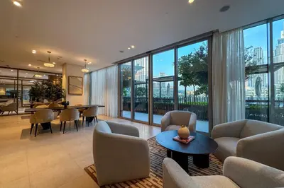 a living room with chairs and tables and large windows at GRaNDE 2BR Best BURJ Khalifa & Fountain, Next to DXB Mall in Dubai