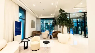 a lobby with white furniture and a palm tree at 1-Bedroom Apartment - Burj Khalifa -Water View in Dubai