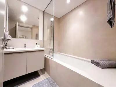 a bathroom with a tub and a sink and a mirror at 1-Bedroom Apartment - Burj Khalifa -Water View in Dubai