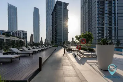 a row of chaise lounges on a deck in a city at Stunning 1BR l Creek Crescent Suite in Dubai