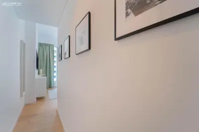a hallway with white walls and pictures on the wall at 29 Boulevard-Burj Khalifa View-Downtown Dubai-Lit Apartment in Dubai