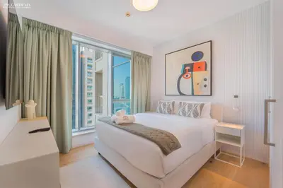 a bedroom with a white bed and a large window at 29 Boulevard-Burj Khalifa View-Downtown Dubai-Lit Apartment in Dubai