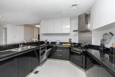 a kitchen with black counters and white cabinets at Luxe Living At Damac heights - Dubai Marina - Marina & Sea Views in Dubai