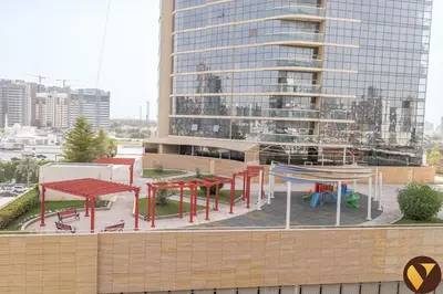 a group of tables and benches in front of a building at Vogue JVC Binghatti Phoenix near Circle Mall, Studio Apartment with Balcony and Access to all Amenities in Dubai