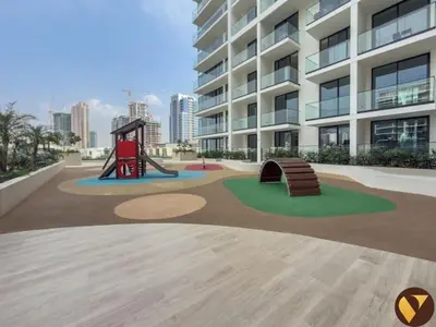 a playground in front of a large building at Vogue JVC Binghatti Phoenix near Circle Mall, Studio Apartment with Balcony and Access to all Amenities in Dubai