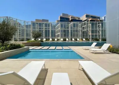a swimming pool with two lounge chairs and a building at Luxury 1BR near Burj Khalifa Business Bay Free Parking in Dubai