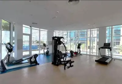 a gym with treadmills and exercise equipment in a building at Luxury 1BR near Burj Khalifa Business Bay Free Parking in Dubai
