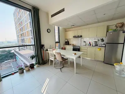 a kitchen with a refrigerator and a table with chairs at 1BR, Afnan 2, Midtown, Dubai Production City in Dubai