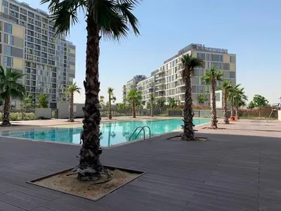 a swimming pool with palm trees and buildings at 1BR, Afnan 2, Midtown, Dubai Production City in Dubai