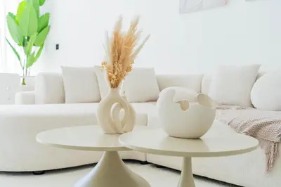 a living room with two tables with vases and a couch at Stunning Burj Khalifa View Luxury 2BR Business Bay in Dubai