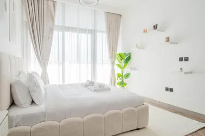 a white bedroom with a white bed and a window at Stunning Burj Khalifa View Luxury 2BR Business Bay in Dubai
