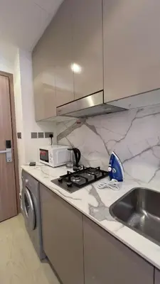 a kitchen with a stove top oven next to a sink at Luxury Studio big Balcony in Dubai