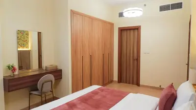 a bedroom with a bed and a desk and a mirror at Stunning 2BR Canal & Burj Khalifa Partial View 4 in Dubai