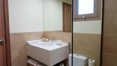 a bathroom with a sink and a mirror and a toilet at Stunning 2BR Canal & City Skyline View 7 in Dubai