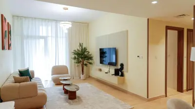 a living room with a couch and a tv on a wall at Elegant 2BR Canal & Burj Khalifa Partial View 5 in Dubai