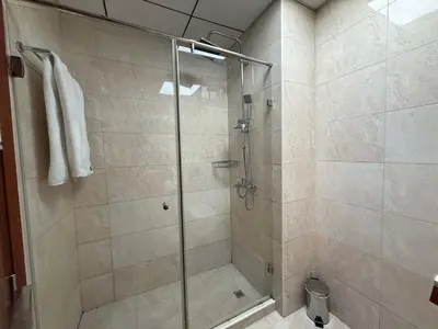 a shower with a glass door in a bathroom at Comfort Focused 1BR Laya JVC in Dubai