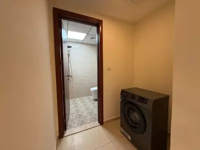 a bathroom with a washing machine and a shower at Comfort Focused 1BR Laya JVC in Dubai