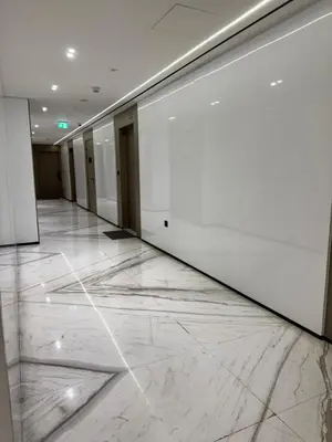 an empty hallway with white walls and marble floors at The Residences in Dubai