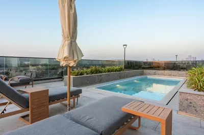a patio with a swimming pool on top of a building at Brand-New Elegant Stay Premium Amenities JVT in Dubai