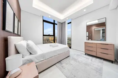 a bedroom with a large bed and a mirror at Brand-New Elegant Stay & Premium Amenities in JVT in Dubai