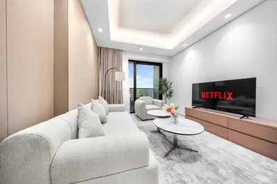 a living room with a couch and a tv at Brand-New Elegant Stay & Premium Amenities in JVT in Dubai