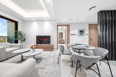a living room with white furniture and a tv at Brand-New Elegant Stay & Premium Amenities in JVT in Dubai