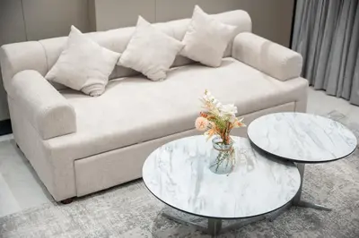 a living room with a couch and two tables at Brand-New Elegant Stay & Premium Amenities in JVT in Dubai